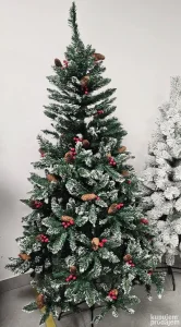 Novogodišnja jelka sa šišarkama i crvenim bobicama predstavl